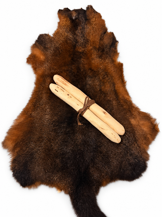 Possum skin and clapsticks bundle on a plain white background